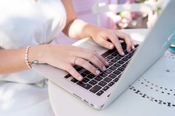 close up of female entrepreneur typing on her laptop
